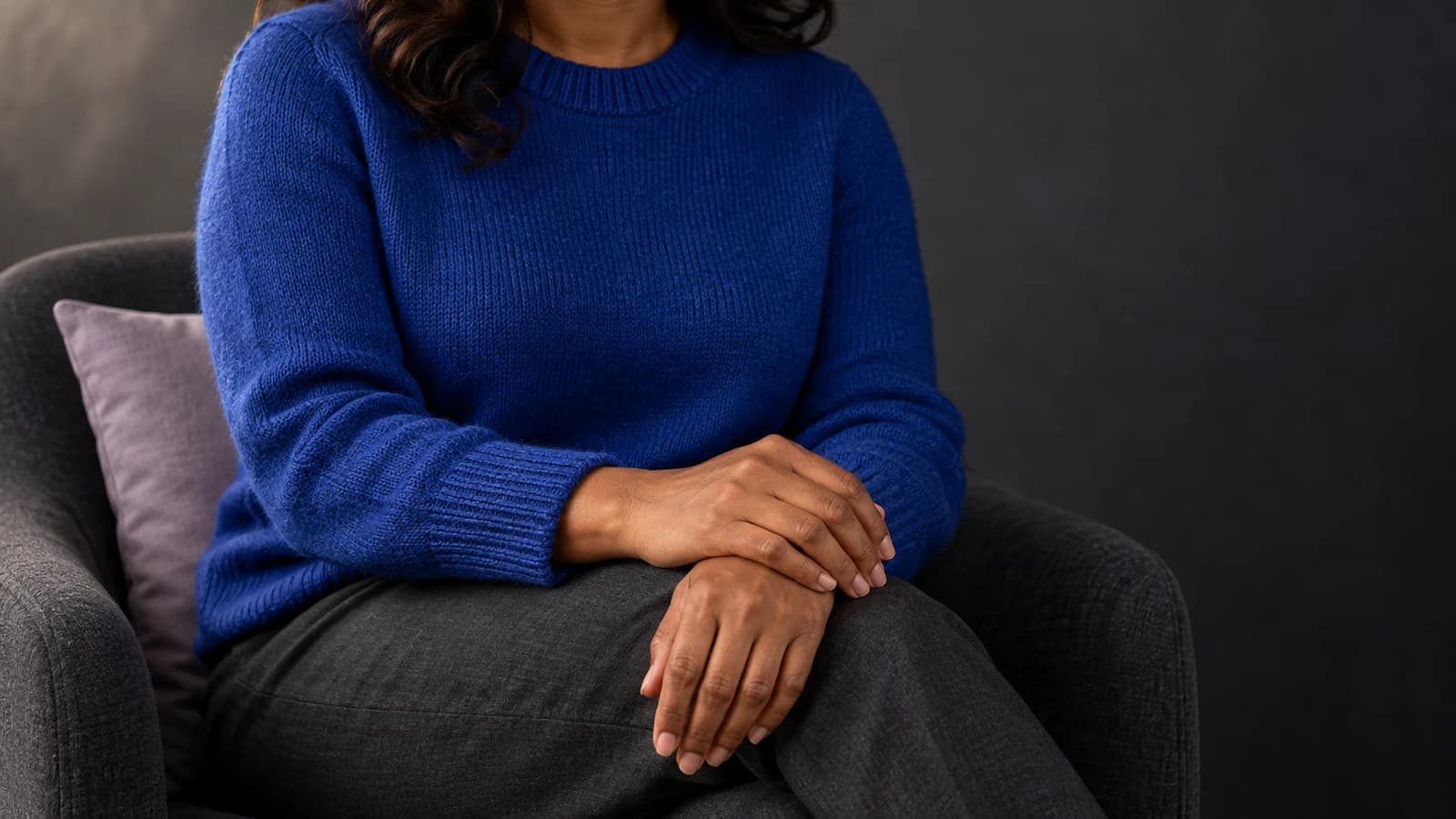 Editorial photograph of natural hands and believable fabric folds on a fully clothed adult, illustrating anatomy and image realism.
