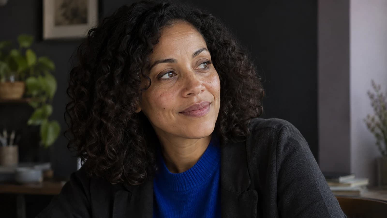 Natural editorial portrait of a fictional adult woman with visible skin texture and an unposed expression, illustrating visual realism.